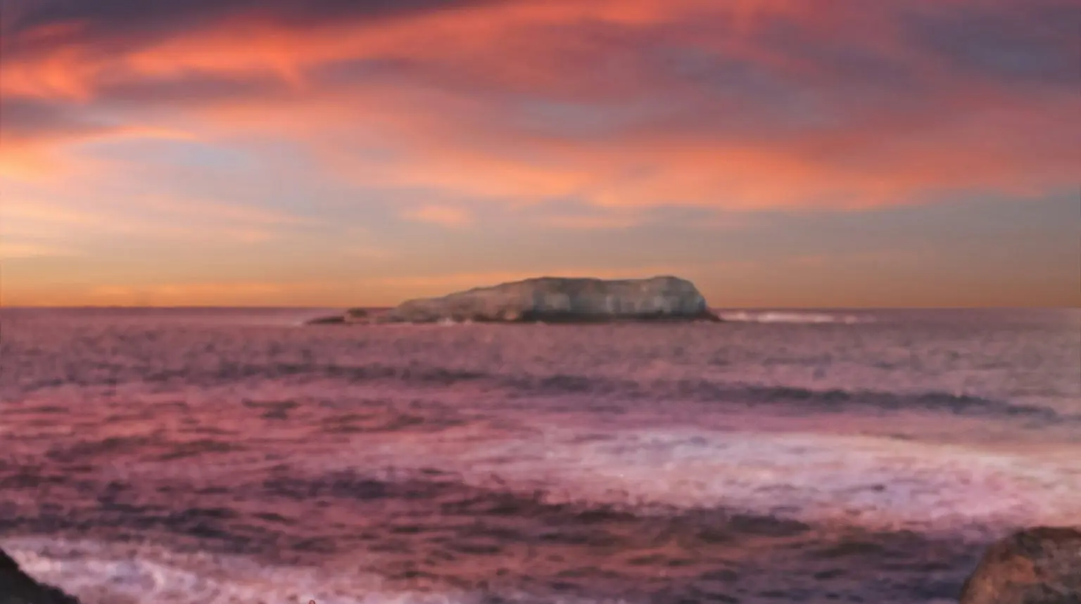 person sitting on rock beside of brindle through sea waves crashing on rock